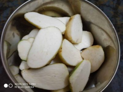 Sliced raw pears in a metal bowl, ready for cooking or serving.