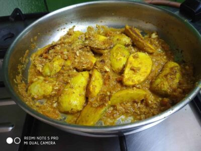Fried banana fritters in a spicy, seasoned batter served in a pan, perfect for snacks or desserts.