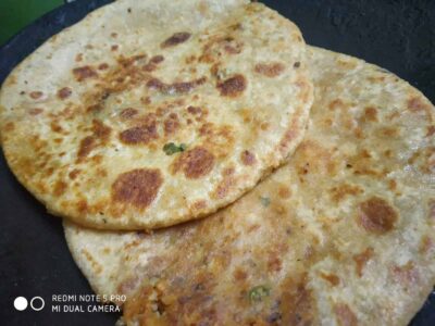 Crispy Indian stuffed paratha served hot on a skillet for breakfast or snack.