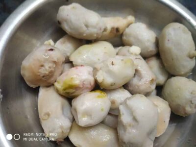 Boiled potato balls in a stainless steel bowl, ready for cooking or further preparation.