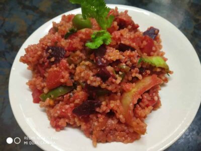 Savory vegetable pulao with rice, tomatoes, peas, and spices on a white plate. Perfect comfort food.