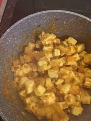 Savory paneer and vegetable curry in a non-stick pan, ready to serve.
