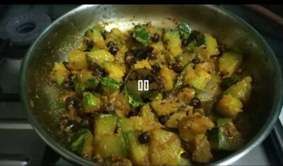 Spicy sautéed cucumber with black pepper and spices in a stainless steel pan.