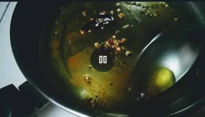 Sautéing mustard seeds and spices in oil for flavorful cooking.
