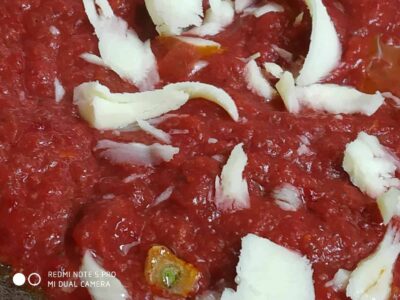 Fresh tomato sauce with cheese and herbs, delicious addition to pasta or pizza, vibrant and flavorful.