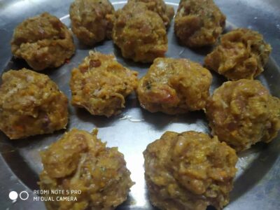 Spicy homemade meatballs on a metal plate, ready to serve.