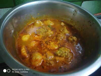 Savory Indian curry simmering with spices and tender ingredients in a stainless steel pot.