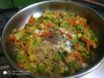 Chopped vegetables with spices in a silver bowl, ready for cooking, vibrant colors and fresh ingredients.