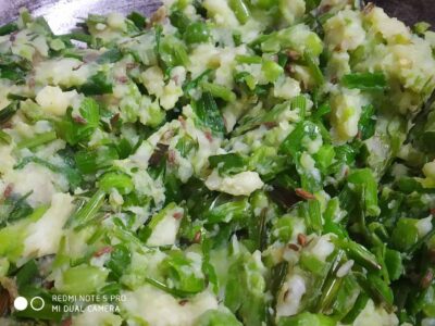 Chopped green vegetables and mashed potatoes, fresh and vibrant, ready for cooking or seasoning.