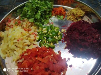 Colorful array of freshly chopped vegetables and herbs for traditional Indian meal preparation.