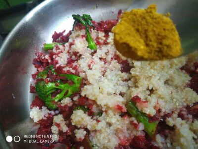 Fresh vegetable upma with green peas and spices, cooked in a stainless steel pan.
