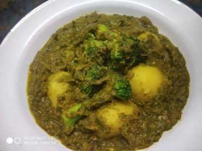 Savory vegetable curry with potatoes and broccoli on a white plate, rich and flavorful Indian vegetarian dish.