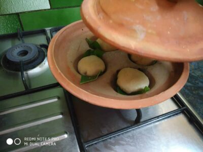 Steamed idlis in traditional clay steamers, ready to serve, a classic South Indian breakfast dish.
