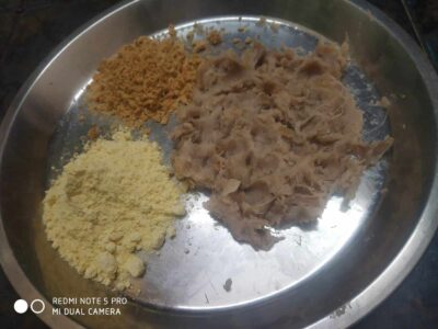 Ground spices and shredded meat on a stainless steel plate for cooking or seasoning.