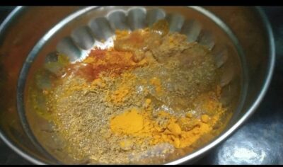 Spices and turmeric powder in stainless steel bowl ready for cooking or seasoning.