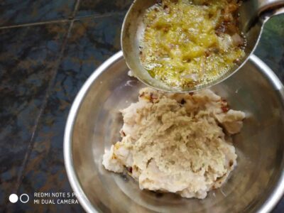 Savory mashed potatoes with flavorful gravy on top, served in a stainless steel bowl.