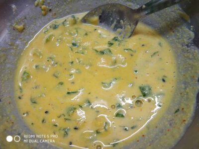 Creamy egg curry with spices and herbs in a stainless steel bowl, perfect for breakfast or a hearty meal.
