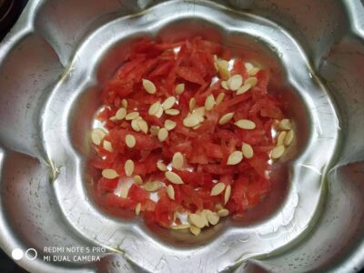 Freshly cut watermelon and pumpkin seeds in stainless steel bowl for a healthy snack or recipe ingredient.