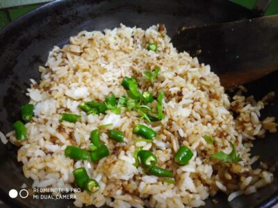 Steamed rice with green chili garnished for a flavorful meal option.