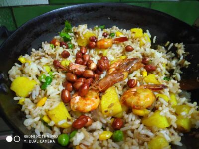 Creamy shrimp and rice pilaf with peanuts, vegetables, and herbs for savory flavor.
