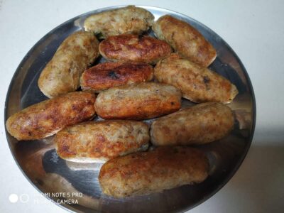 Fried Indian snacks served on a stainless steel plate, crispy and golden brown.