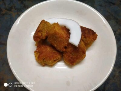 Crispy fried snacks with coconut chutney on white plate, Indian street food style.