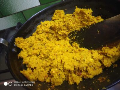 Savory yellow turmeric mashed potatoes in a black skillet for flavorful dish preparation.