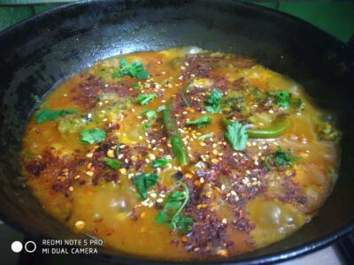 Spicy Indian egg scramble with herbs, spices, and chili flakes in a Indian-style skillet.